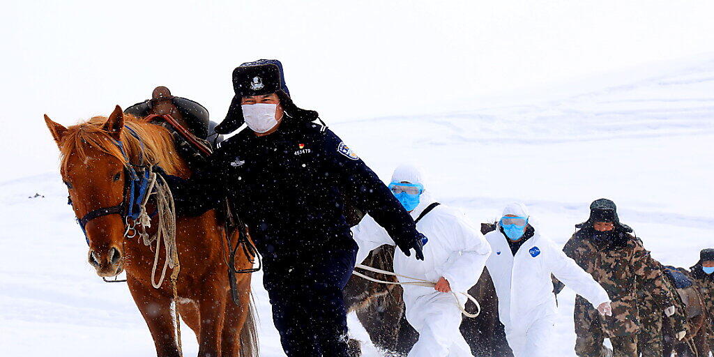 Chinesische Grenzsoldaten versuchen abgelegene Bergdörfer in China über das neuartige Coronavirus zu informieren. (Foto: A RAN/EPA Keystone-SDA)