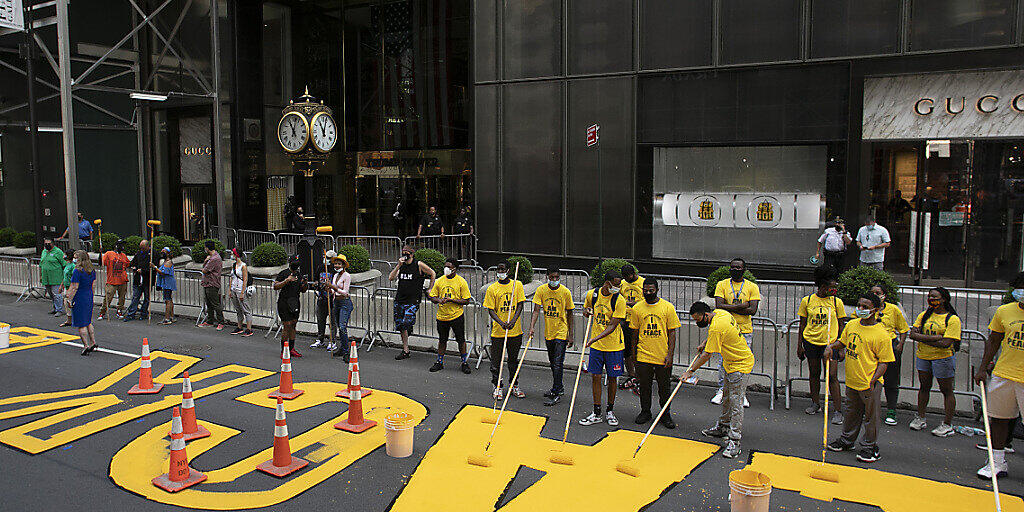 Künstler und Aktivisten malen den Schriftzug "Black Lives Matter" auf New Yorks Fifth Avenue vor dem Trump Tower. (Foto: Mark Lennihan/AP/KEYSTONE-SDA)