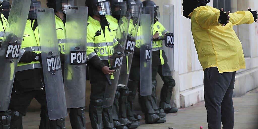 Ein Demonstrant steht während eines Protests gegen die Regierung vor Polizisten. Foto: Fernando Vergara/AP/dpa