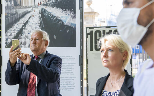 Hans Stöckli (l.) und Isabelle Moret (Mitte) besuchen eine Fotoausstellung über die Nahrungsmittelverteilung an Bedürftige während der Corona-Krise in Genf.