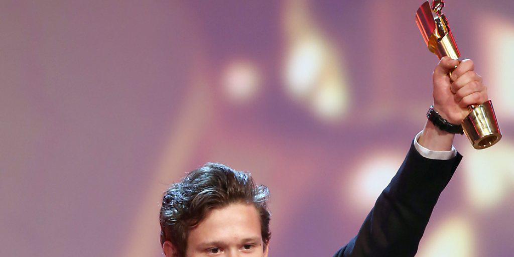 Joel Basman mit der Trophäe des deutschen Filmpreises. Die goldene Lola erhielt er für die beste Nebenrolle.
