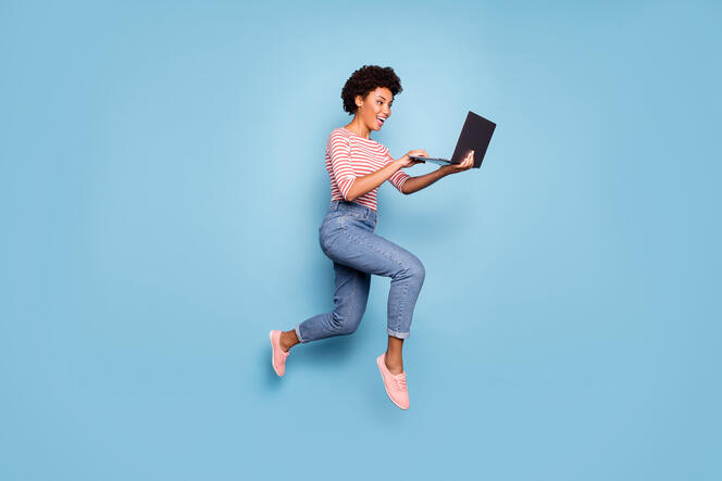 Full length body size side profile photo of pretty cheerful cute nice charming youngster typing before laptop wearing jeans denim striped shirt isolated pastel color blue background