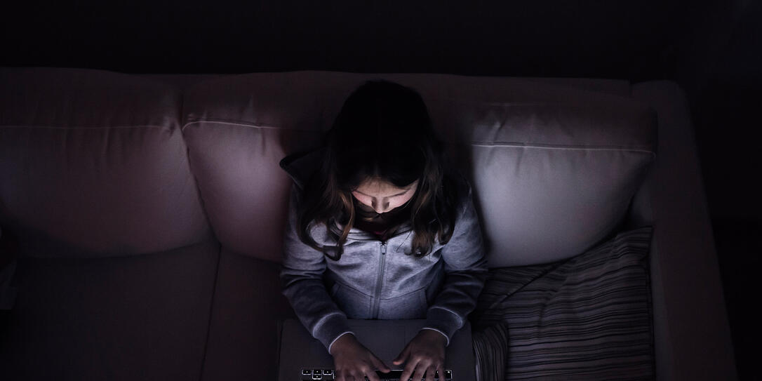 Little girl, sitting in a dark, playing with laptop Little girl, sitting in a dark, playing with laptop