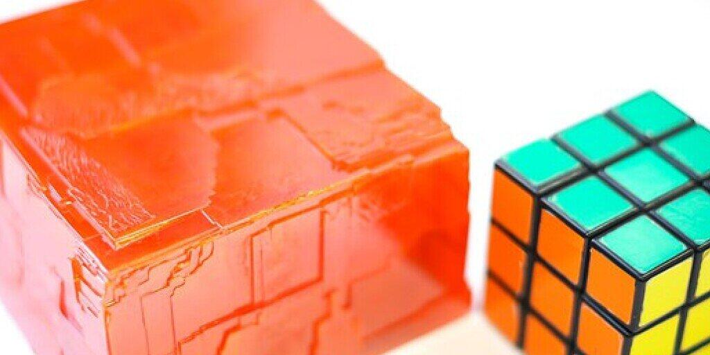 EPFL-Forscher haben einen Perowskit (l neben einem Rubik-Würfel) gezüchtet, der Gammastrahlen entdeckt. Im Unterschied zu bisher bekannten Perowskiten, haben die Forscher den CH3NH3PbBr3-Kristall zu einem "Mocken" von 3,8 Kilo hochgezüchtet. Das macht ihn fit für die industrielle Herstellung (zVg).