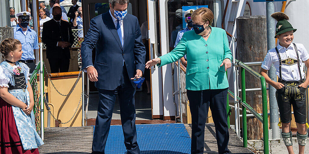 Markus Söder (CSU), Ministerpräsident von Bayern, empfängt an der Schiffsanlegestelle Prien Bundeskanzlerin Angela Merkel (CDU), um anschließend mit einem Schiff der Chiemsee-Schifffahrt auf die Insel Herrenchiemsee überzusetzen. Foto: Peter Kneffel/dpa/Pool/dpa