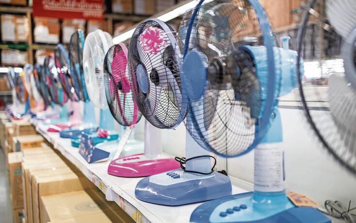 Fan for cooling in an electronics shop,various brands of electrical fans display on a shelf at supermarket in sunny hot summer day,choosing to buy energy efficient appliances,save energy concept
