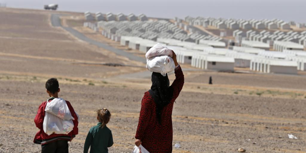 Syrische Flüchtlinge vor einem Zeltcamp in Jordanien.