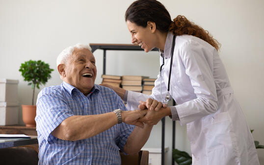 Caring female doctor support and cheer elderly man