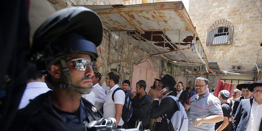 Ein israelischer Grenzpolizist steht bewaffnet vor der Klagemauer: Der traditionelle Priestersegen lockt Tausende Gläubige nach Jerusalem.