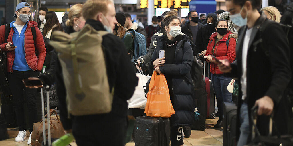 Reisende warten am letzten Samstag vor Weihnachten in der Bahnhofshalle der Londoner Paddington Station. Foto: Stefan Rousseau/PA/dpa