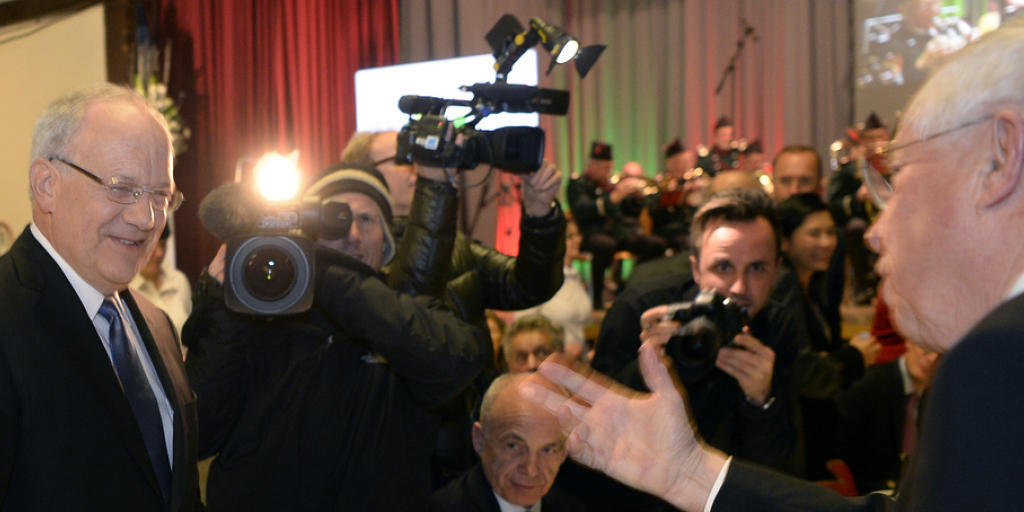 Bundespr&auml;sident Johann Schneider-Ammann und Alt-Bundesrat Christoph Blocher (in Bildmitte sitzend Bundesrat Ueli Maurer) umringt von Medienschaffenden an der 28. Albisg&uuml;etli-Tagung der Z&uuml;rcher SVP am Freitagabend.