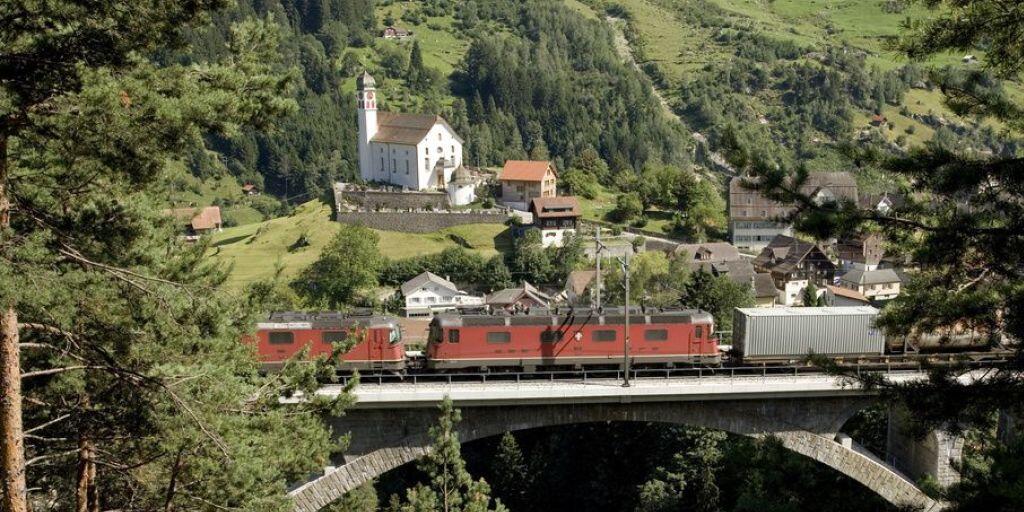Ein Güterzug mit mehreren Lokomotiven passiert auf der Gotthardstrecke bei Wassen eine Eisenbahnbrücke. Der Güterverkehr durch die Schweizer Alpen hat im ersten Halbjahr 2019 abgenommen - auf der Strasse ebenso wie auf der Schiene. (Archivbild)
