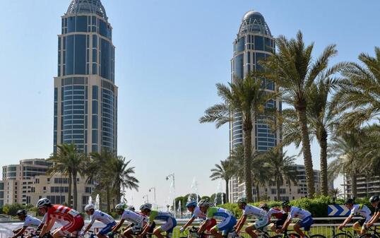 Das Juniorenfeld entlang von Palmen und Hochhäusern in Doha