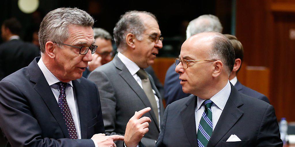 Der deutsche Innenminister Thomas de Maiziere (links) spricht mit seinem französischen Amtskollegen Bernard Cazeneuve am EU-Innenministertreffen in Brüssel.