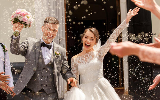 Happy wedding photography of bride and groom at wedding ceremony. Wedding tradition sprinkled with rice and grain