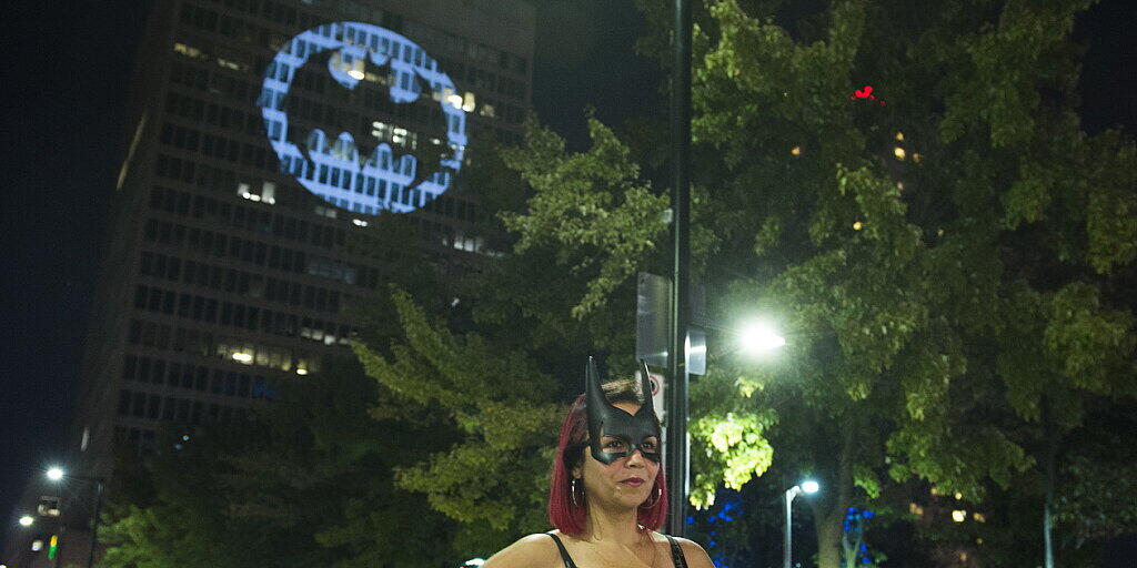 Ein Batman-Fan posiert vor einem Leuchtsignal in der kanadischen Metropole Montreal.