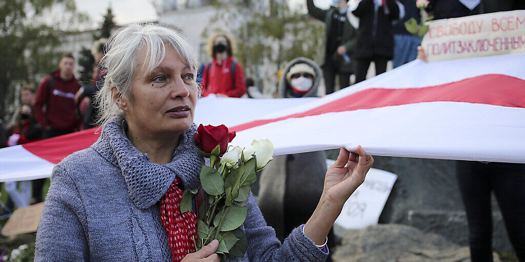 dpatopbilder - Eine Frau hält bei einer Demonstration Rosen und die historische weiß-rot-weiße Fahne in der Hand. Tausende Menschen, darunter vor allem Senioren und Studenten, marschierten am Montag durch die Hauptstadt. Foto: -/AP/dpa dpatopbilder - Eine Frau hält bei einer Demonstration Rosen und die historische weiß-rot-weiße Fahne in der Hand. Tausende Menschen, darunter vor allem Senioren und Studenten, marschierten am Montag durch die Hauptstadt. Foto: -/AP/dpa