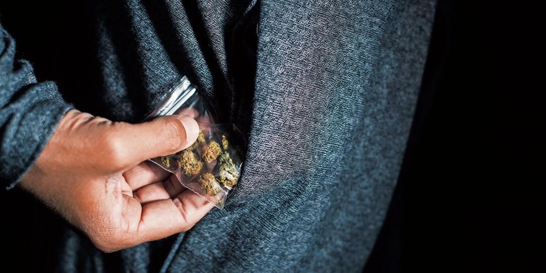 young man with a bag of marihuana buds young man with a bag of marihuana buds