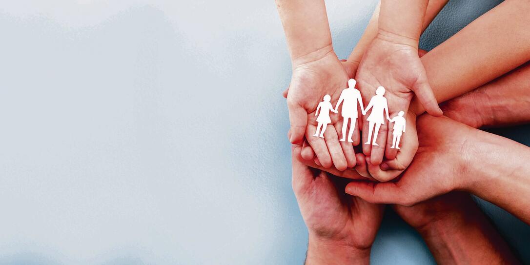 Family care concept. Hands with paper silhouette on table. Family care concept. Hands with paper silhouette on table.