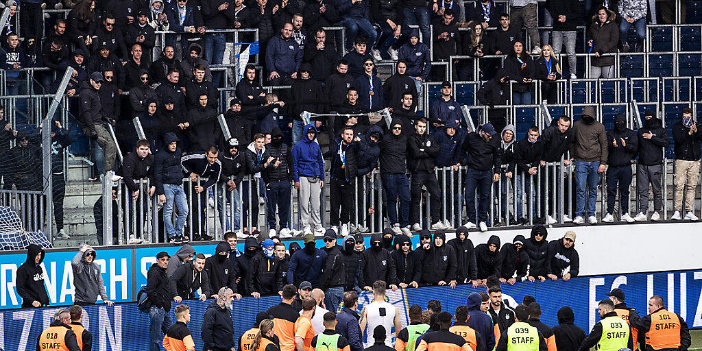 GC-Spieler stehen vor GC-Hooligans nach dem Abbruch eines Spiels zwischen dem FC Luzern und dem Grasshopper Club Zürich. Der Ständerat hat am Dienstag über solche Vorfälle diskutiert und ein Hooligan-Abkommen genehmigt. (Archivbild) GC-Spieler stehen vor GC-Hooligans nach dem Abbruch eines Spiels zwischen dem FC Luzern und dem Grasshopper Club Zürich. Der Ständerat hat am Dienstag über solche Vorfälle diskutiert und ein Hooligan-Abkommen genehmigt. (Archivbild)