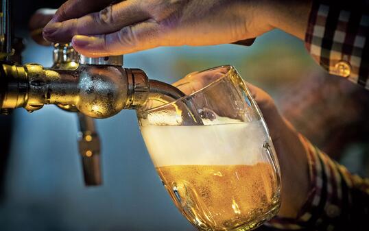 Male bartender pouring beer into glass