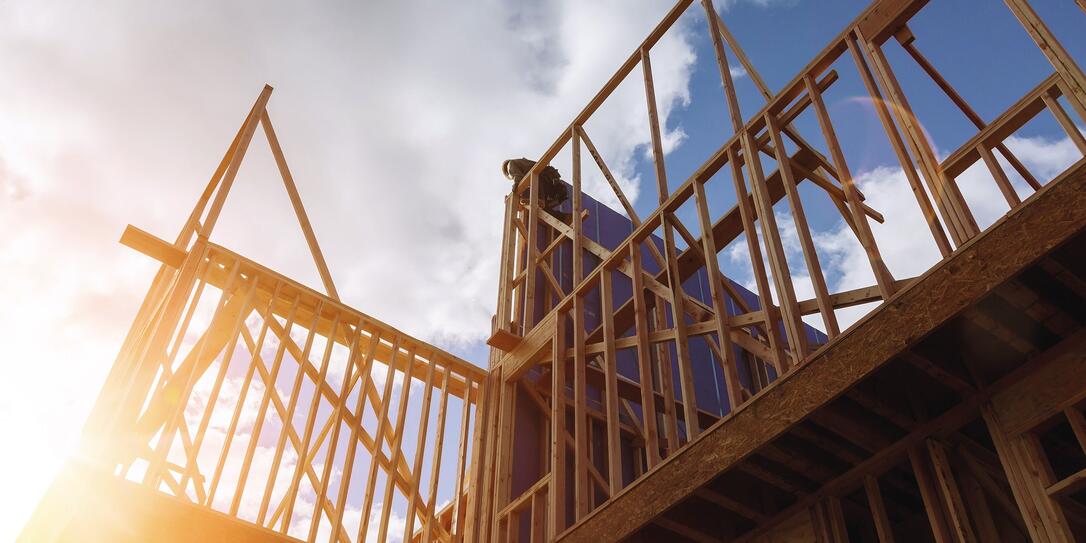 builder at work with wooden roof construction Wood Building frame