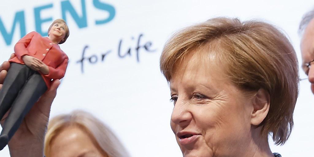 Siemens muss in Deutschland Federn lassen. Im Bild ist die deutsche Kanzlerin Angela Merkel bei einem Besuch an der Messe Hannover am Stand von Siemens. (Archiv)