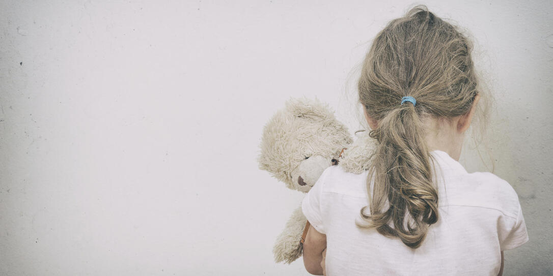 Little girl crying in the corner. Domestic violence concept.