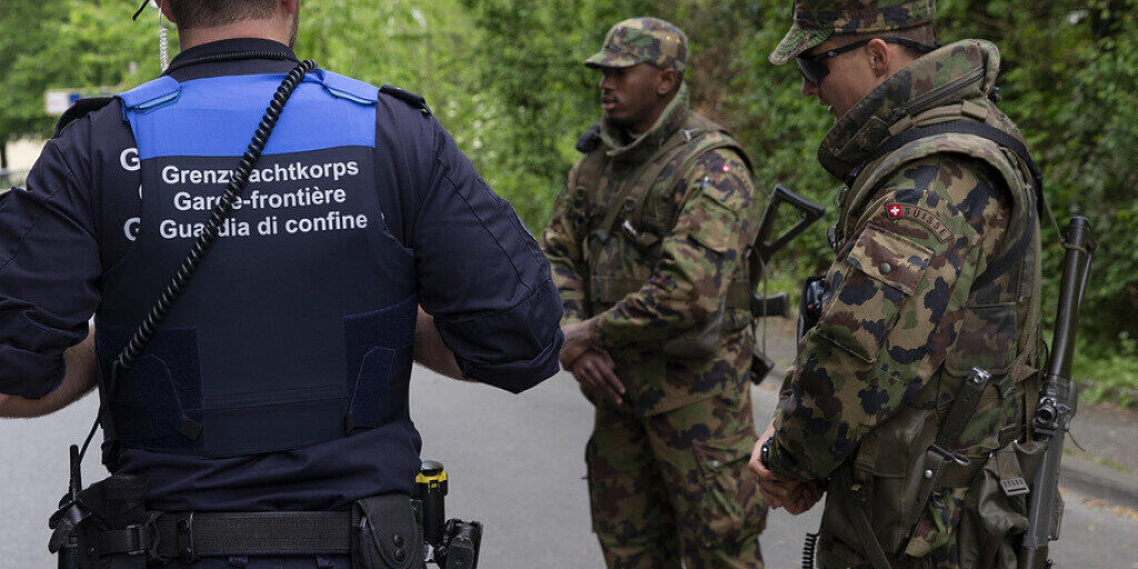 Ein Schweizer Grenzbeamter und Soldaten sichern die Grenze bei Thonex vor Corona-Sündern. Künftig - so will es das revidierte Zollgesetz - könnten auch Handelswarenzollbeamte mit Waffen aufgerüstet werden. Das stösst den meisten, die sich zum Gesetzesentwurf vernehmen lassen, sauer auf. (Symbolbild)