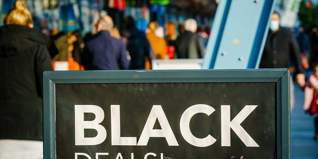 Passanten gehen vor einem Einkaufszentrum an einem Schild vorbei, das auf «Black Friday»-Angebote hinweist. Menschenmassen in Einkaufsstraßen und drohende Verstöße gegen Corona-Regeln: In den Niederlanden lehnen sich Städte gegen die Verkaufsaktion «Black Friday» auf. Foto: Marco De Swart/ANP/dpa Passanten gehen vor einem Einkaufszentrum an einem Schild vorbei, das auf «Black Friday»-Angebote hinweist. Menschenmassen in Einkaufsstraßen und drohende Verstöße gegen Corona-Regeln: In den Niederlanden lehnen sich Städte gegen die Verkaufsaktion «Black Friday» auf. Foto: Marco De Swart/ANP/dpa