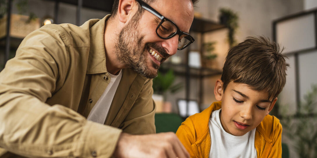 Father show son how to save money at piggy bank at home