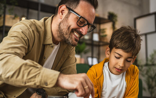 Father show son how to save money at piggy bank at home