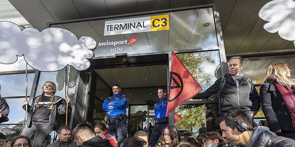 Rund 100 Aktivisten der Extinction Rebellion blockieren die Zufahrtsstrassen zum Privatjet-Terminal des Genfer Flughafens.