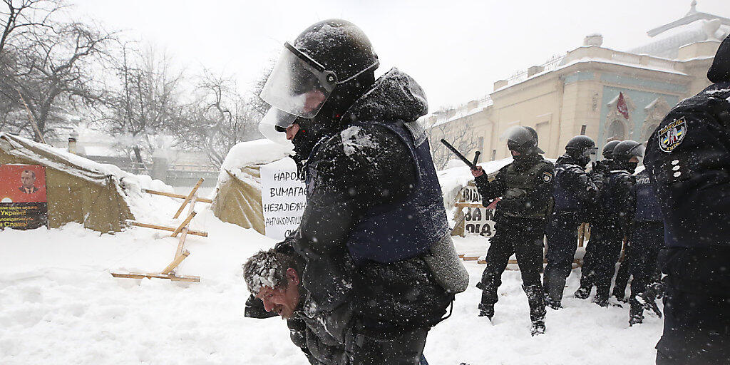 Polizisten in Kiew nehmen einen Demonstranten fest und räumen ein Zeltlager vor dem Parlament.