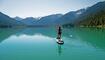 Woman SUP boards across mountain lake