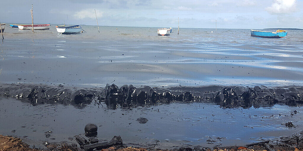 HANDOUT - Ein Ölteppich bedeckt das Wasser vor dem Strand, nachdem bereits am 25. Juli der Frachter «Wakashio» vor der Ostküste von Mauritius auf Grund lief und inzwischen begonnen hat, Kraftstoff aus einem Tank zu verlieren. Foto: Sophie Seneque/AP/dpa - ACHTUNG: Nur zur redaktionellen Verwendung und nur mit vollständiger Nennung des vorstehenden Credits