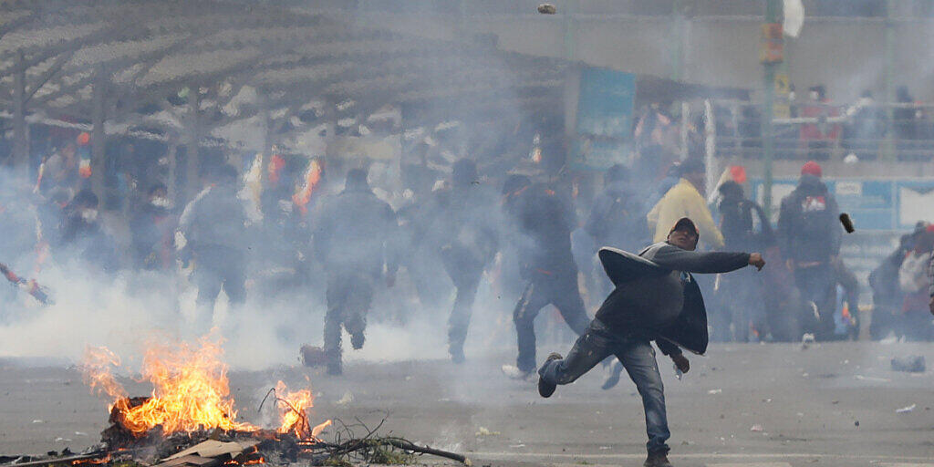 Anhänger des gestürzten bolivianischen Präsidenten Evo Morales werfen in der Hauptstadt La Paz Steine auf Polizisten.