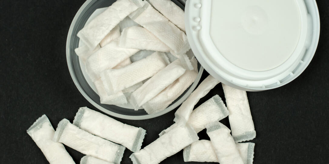 Open box with snus on a black background. Swedish nicotine sachets