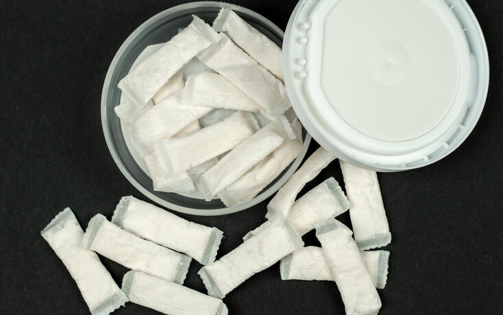 Open box with snus on a black background. Swedish nicotine sachets