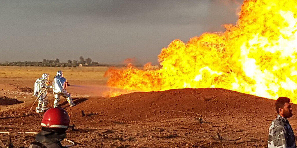 HANDOUT - Auf diesem Foto, das von der offiziellen syrischen Nachrichtenagentur SANA veröffentlicht wurde, löschen syrische Feuerwehrleute die Flammen einer Gaspipeline, die von einer Explosion zwischen den nordöstlichen Damaszener Vororten Adra und Dumair getroffen wurde. Foto: SANA/AP/dpa - ACHTUNG: Nur zur redaktionellen Verwendung und nur mit vollständiger Nennung des vorstehenden Credits HANDOUT - Auf diesem Foto, das von der offiziellen syrischen Nachrichtenagentur SANA veröffentlicht wurde, löschen syrische Feuerwehrleute die Flammen einer Gaspipeline, die von einer Explosion zwischen den nordöstlichen Damaszener Vororten Adra und Dumair getroffen wurde. Foto: SANA/AP/dpa - ACHTUNG: Nur zur redaktionellen Verwendung und nur mit vollständiger Nennung des vorstehenden Credits