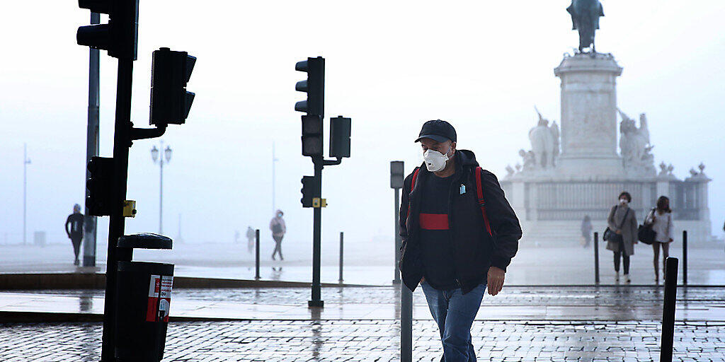 Ein Mann mit Mund-Nasen-Schutz geht durch Lissabon. Foto: Pedro Fiuza/ZUMA Wire/dpa