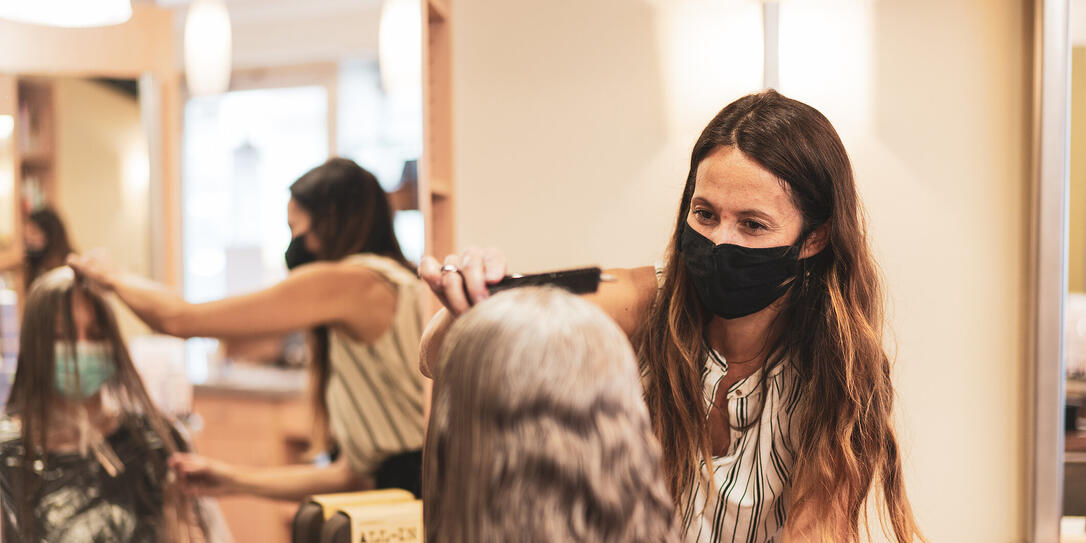 hairdresser with mask enjoying to work again in her hair salon after lockdown is over hairdresser with mask enjoying to work again in her hair salon after lockdown is over