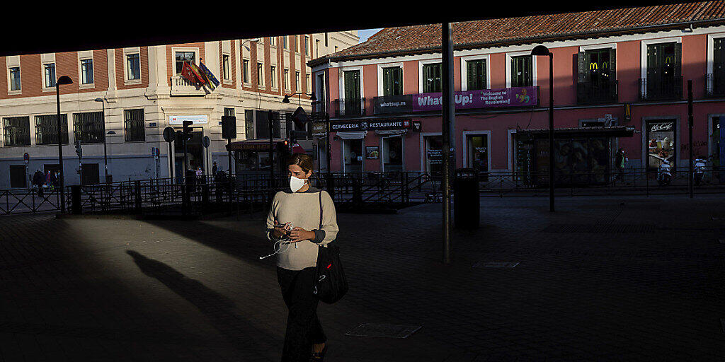 Eine Frau mit Gesichtsmaske auf einem Platz in der spanischen Hauptstadt. Foto: Bernat Armangue/AP/dpa
