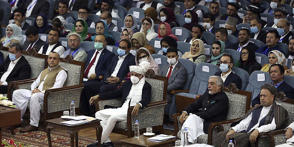 Aschraf Ghani (M), Präsident von Afghanistan, trägt eine FFP-Maske bei der Loja Dschirga, der großen Ratsversammlung. Ghani hatte die Loja Dschirga einberufen, um über das Schicksal von 400 inhaftierten Taliban zu entscheiden, denen teils schwerste Verbrechen vorgeworfen werden. Foto: Rahmat Gul/AP/dpa