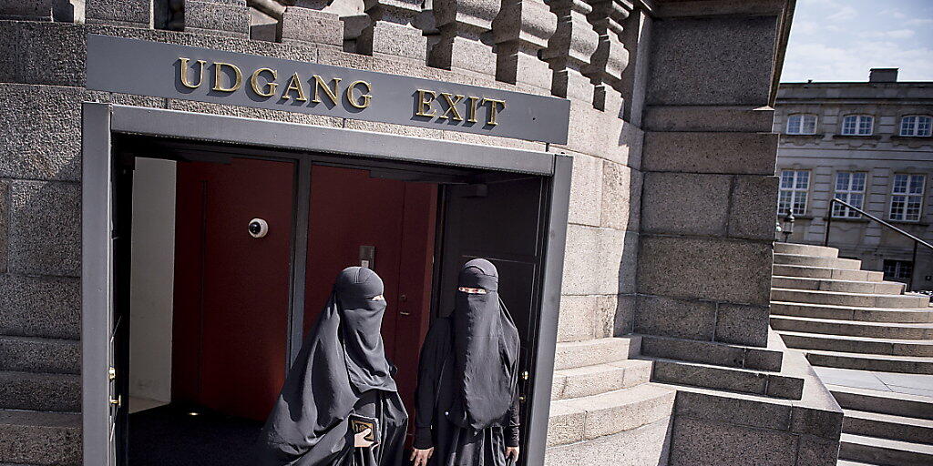 Zwei Nikab-tragende Frauen verlassen das dänische Parlament, nachdem dieses das Verbot der Vollverschleierung beschlossen hat. (Archiv)