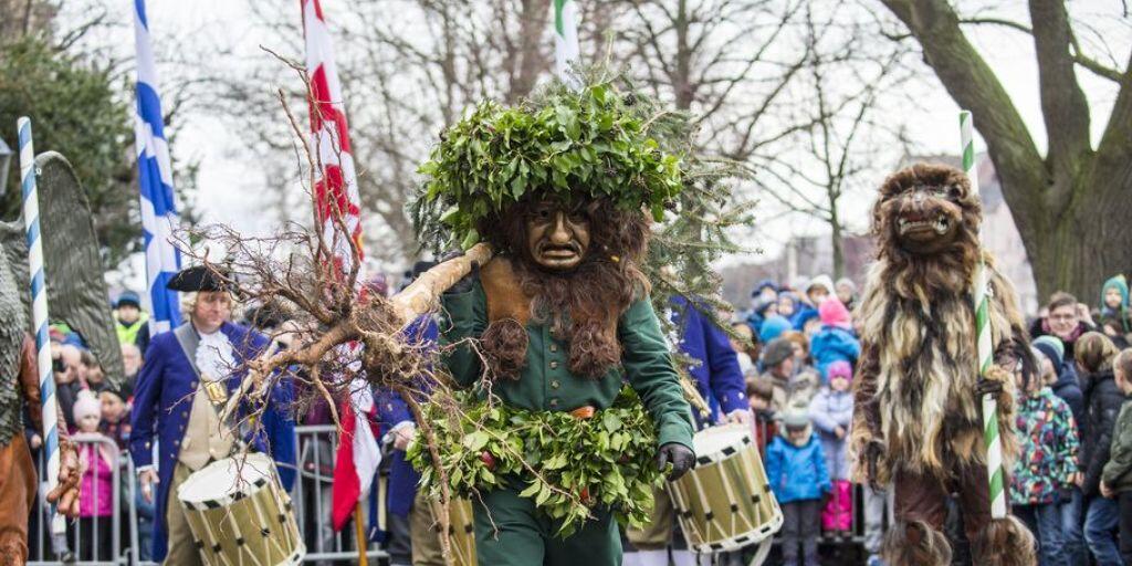 Brauchtum in Basel: Der "Wild Maa" trägt einen über mannshohen Tannenbaum in den Händen.