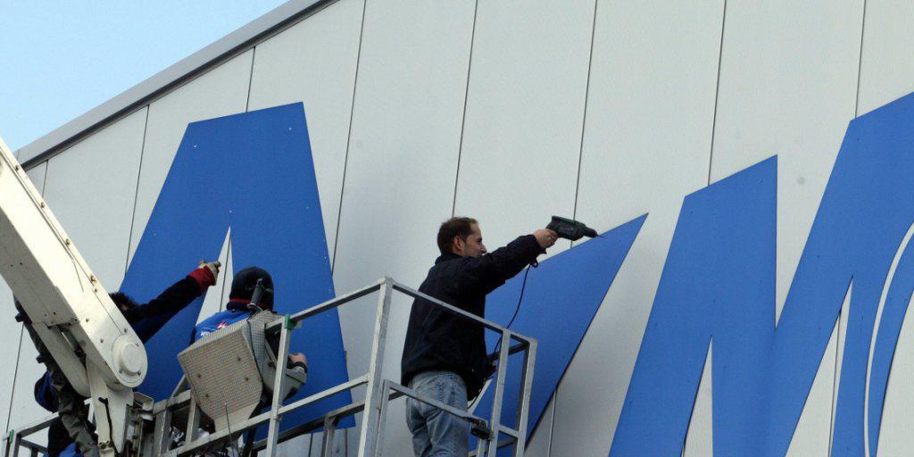 Arbeiter entfernen im März 2006 anlässlich der offiziellen Stabsübergabe der AZM an Emmi den Schriftzug AZM an der Fassade der Aargauer Zentralmolkerei in Suhr. (Archivbild) Arbeiter entfernen im März 2006 anlässlich der offiziellen Stabsübergabe der AZM an Emmi den Schriftzug AZM an der Fassade der Aargauer Zentralmolkerei in Suhr. (Archivbild)