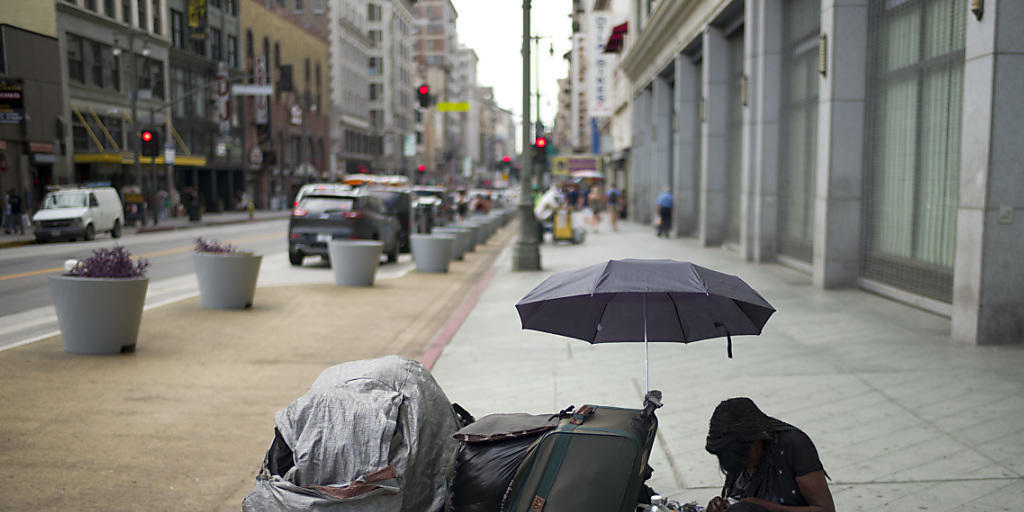 Eine obdachlose Frau auf einem Trottoir in Los Angeles mit ihren Habseligkeiten Eine obdachlose Frau auf einem Trottoir in Los Angeles mit ihren Habseligkeiten