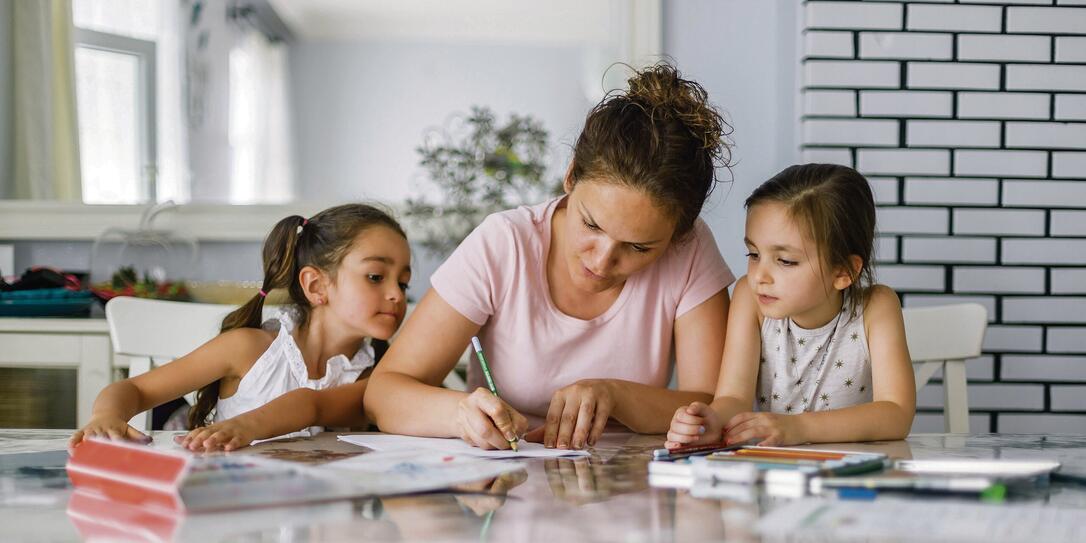 Mother helping daughters with homework