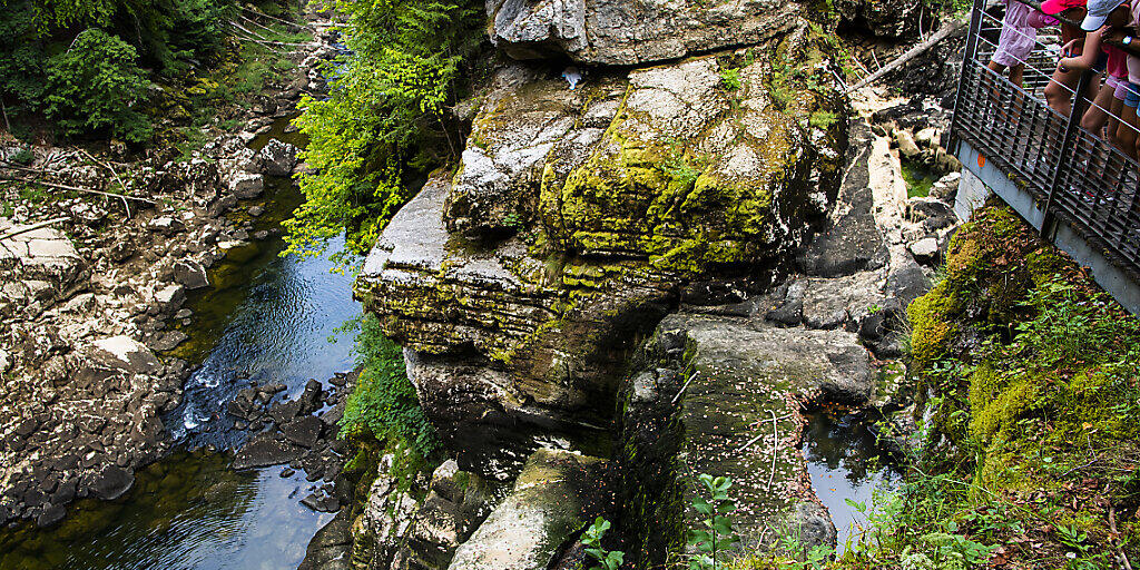 Der Saut-du-Doubs an der französisch-schweizerischen Grenze ist ausgetrocknet. Einige junge Leute sprangen am Mittwoch über die zugänglichen Steine in das darunter liegende Wasser.